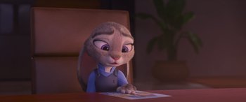 Movie still from “Zootopia” (2016), directed by Jared Bush – A bunny sitting at a table looking at a piece of paper; Close Up shot, Over the shoulder angle
