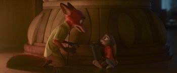 Movie still from “Zootopia” (2016), directed by Jared Bush – A statue of a man and a woman sitting on the floor; Medium shot, High angle
