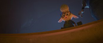 Movie still from “Zootopia” (2016), directed by Jared Bush – A stuffed sheep wearing glasses sitting on top of a ledge; Medium shot, Low angle