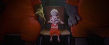 Movie still from “Zootopia” (2016), directed by Jared Bush – A person sitting in a chair with two other people standing next to it; Wide shot, High angle