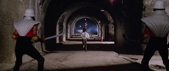 Movie still from “1990: The Bronx Warriors” (1982), directed by Enzo G. Castellari – A man running through a tunnel at night time; Extreme Wide shot, High angle