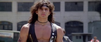 Movie still from “1990: The Bronx Warriors” (1982), directed by Enzo G. Castellari – A man with long curly hair wearing a leather vest; Close Up shot, Low angle