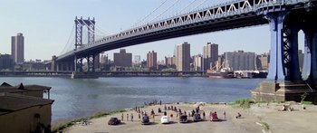 Movie still from “1990: The Bronx Warriors” (1982), directed by Enzo G. Castellari – A group of people standing on top of a sandy beach next to a body of water; Extreme Wide shot, High angle