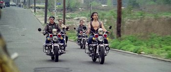 Movie still from “1990: The Bronx Warriors” (1982), directed by Enzo G. Castellari – A group of men riding motorcycles down a street; Wide shot, Low angle