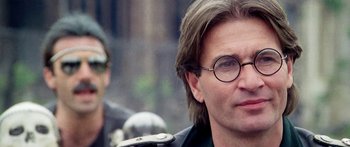 Movie still from “1990: The Bronx Warriors” (1982), directed by Enzo G. Castellari – A person wearing glasses and a leather jacket; Close Up shot, Over the shoulder angle