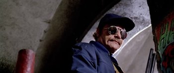 Movie still from “1990: The Bronx Warriors” (1982), directed by Enzo G. Castellari – A person wearing sunglasses and a hat; Close Up shot, Low angle
