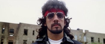 Movie still from “1990: The Bronx Warriors” (1982), directed by Enzo G. Castellari – A person wearing sunglasses and a headband; Close Up shot, Low angle