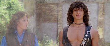 Movie still from “1990: The Bronx Warriors” (1982), directed by Enzo G. Castellari – A man with long hair and a black tank top; Close Up shot, Low angle