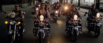 Movie still from “1990: The Bronx Warriors” (1982), directed by Enzo G. Castellari – A group of people riding motorcycles down a street; Wide shot, High angle