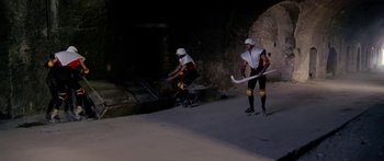 Movie still from “1990: The Bronx Warriors” (1982), directed by Enzo G. Castellari – A man riding a skateboard down a ramp; Wide shot, High angle