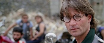Movie still from “1990: The Bronx Warriors” (1982), directed by Enzo G. Castellari – A person wearing glasses with a motorcycle in the background; Close Up shot, Low angle