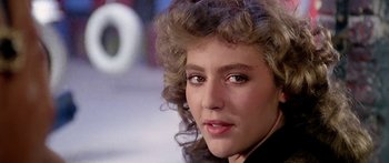 Movie still from “1990: The Bronx Warriors” (1982), directed by Enzo G. Castellari – A woman's face in a black shirt; Close Up shot, Over the shoulder angle