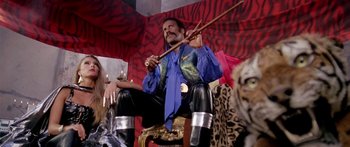 Movie still from “1990: The Bronx Warriors” (1982), directed by Enzo G. Castellari – A man sitting on a chair holding a stick; Medium shot, Low angle