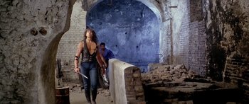 Movie still from “1990: The Bronx Warriors” (1982), directed by Enzo G. Castellari – A man and a woman are walking through a tunnel; Wide shot, Low angle