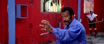 Movie still from “1990: The Bronx Warriors” (1982), directed by Enzo G. Castellari – A man in a blue shirt is holding a metal object; Medium shot, High angle