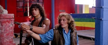 Movie still from “1990: The Bronx Warriors” (1982), directed by Enzo G. Castellari – A man and a woman standing next to each other; Medium shot, Low angle