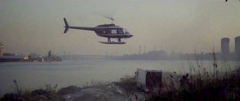 Movie still from “1990: The Bronx Warriors” (1982), directed by Enzo G. Castellari – A helicopter is flying over a truck near a body of water; Extreme Wide shot, Low angle