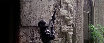 Movie still from “1990: The Bronx Warriors” (1982), directed by Enzo G. Castellari – A man in a black helmet holding a rifle; Medium shot, Low angle