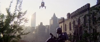 Movie still from “1990: The Bronx Warriors” (1982), directed by Enzo G. Castellari – A statue of a man on a motorcycle in the middle of a city; Extreme Wide shot, Low angle