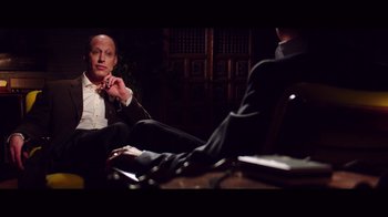 Movie still from “20,000 Days on Earth” (2014), directed by Iain Forsyth – A man sitting in front of another man in a black suit; Medium shot, Over the shoulder angle