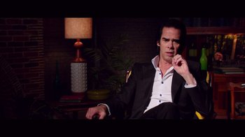 Movie still from “20,000 Days on Earth” (2014), directed by Iain Forsyth – A man sitting in a chair with his hand to his face; Medium shot, Over the shoulder angle