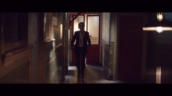 Movie still from “20,000 Days on Earth” (2014), directed by Iain Forsyth – A woman is walking down the hall way of a house; Wide shot, Low angle