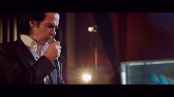 Movie still from “20,000 Days on Earth” (2014), directed by Iain Forsyth – A man holding a microphone in his hand; Close Up shot, Low angle