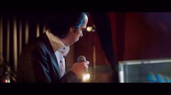 Movie still from “20,000 Days on Earth” (2014), directed by Iain Forsyth – A man holding a microphone in his hand; Medium shot, Low angle