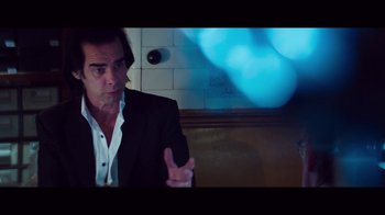 Movie still from “20,000 Days on Earth” (2014), directed by Iain Forsyth – A man sitting in a booth talking to someone; Medium shot, Over the shoulder angle