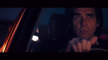 Movie still from “20,000 Days on Earth” (2014), directed by Iain Forsyth – A man sitting in the back seat of a car at night; Close Up shot, Low angle