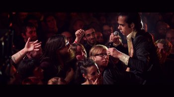 Movie still from “20,000 Days on Earth” (2014), directed by Iain Forsyth – A group of people in a room with microphones; Medium shot, Over the shoulder angle