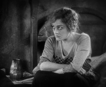 Movie still from “7th Heaven” (1927), directed by Frank Borzage – A woman sitting on a chair with her arms crossed; Medium shot, High angle