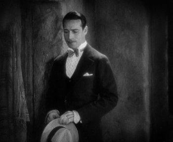 Movie still from “7th Heaven” (1927), directed by Frank Borzage – A man in a suit and tie holding a hat; Medium shot, High angle