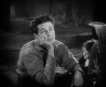Movie still from “7th Heaven” (1927), directed by Frank Borzage – A man sitting on the ground talking on a cell phone; Medium shot, High angle