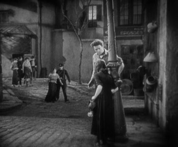 Movie still from “7th Heaven” (1927), directed by Frank Borzage – A black - and - white photo of people in a courtyard; Wide shot, High angle