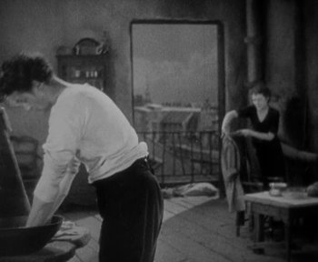 Movie still from “7th Heaven” (1927), directed by Frank Borzage – An old photo of a man and a woman cooking in a kitchen; Medium shot, High angle