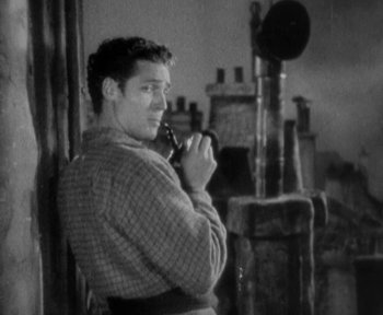 Movie still from “7th Heaven” (1927), directed by Frank Borzage – A black and white photo of a man smoking a pipe; Medium shot, High angle