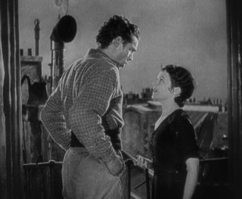 Movie still from “7th Heaven” (1927), directed by Frank Borzage – A man and a woman standing next to each other on a bridge; Medium shot, Low angle