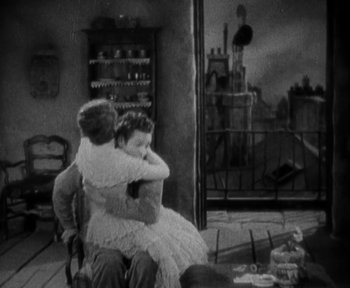 Movie still from “7th Heaven” (1927), directed by Frank Borzage – A man and a woman sitting on a chair hugging; Medium shot, High angle