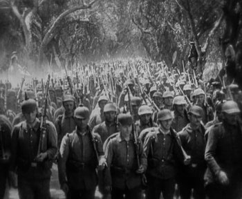 Movie still from “7th Heaven” (1927), directed by Frank Borzage – A large group of men are marching down a road; Wide shot, High angle