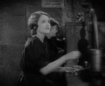 Movie still from “7th Heaven” (1927), directed by Frank Borzage – A black - and - white photo of a woman holding a tray; Medium shot, High angle