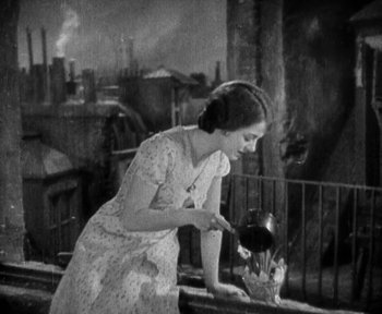 Movie still from “7th Heaven” (1927), directed by Frank Borzage – An old photo of a woman holding a teapot; Medium shot, High angle