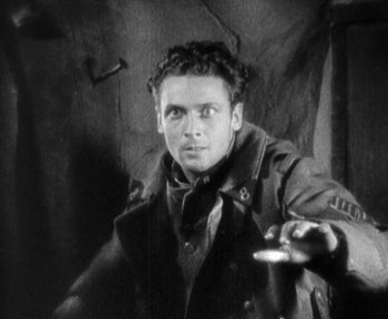 Movie still from “7th Heaven” (1927), directed by Frank Borzage – A man in a trench coat holding something in his hand; Close Up shot, High angle