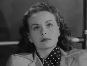 Movie still from “A Letter to Three Wives” (1949), directed by Joseph L. Mankiewicz – An old black and white photo of a woman with a polka dot neck tie; Close Up shot, High angle