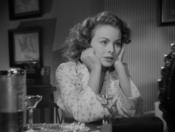 Movie still from “A Letter to Three Wives” (1949), directed by Joseph L. Mankiewicz – A black and white photo of a woman sitting at a table; Close Up shot, High angle