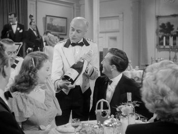 Movie still from “A Letter to Three Wives” (1949), directed by Joseph L. Mankiewicz – A man pouring champagne into a woman's wine glass; Medium shot, Over the shoulder angle