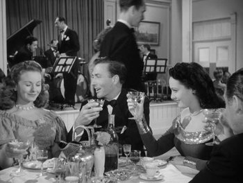 Movie still from “A Letter to Three Wives” (1949), directed by Joseph L. Mankiewicz – A black and white photo of a group of people at a table; Medium shot, Low angle