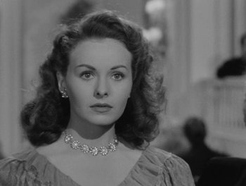 Movie still from “A Letter to Three Wives” (1949), directed by Joseph L. Mankiewicz – A black and white photo of a woman in a dress; Close Up shot, Over the shoulder angle