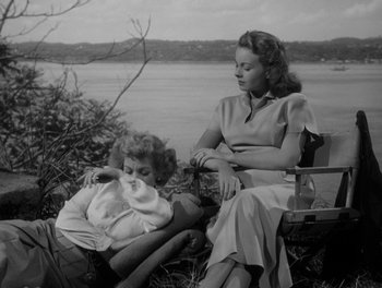 Movie still from “A Letter to Three Wives” (1949), directed by Joseph L. Mankiewicz – A woman and a girl sitting on a bench near a body of water; Medium shot, Low angle