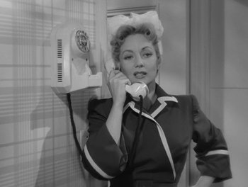 Movie still from “A Letter to Three Wives” (1949), directed by Joseph L. Mankiewicz – A woman talking on a phone while wearing a hair curler; Medium shot, Low angle